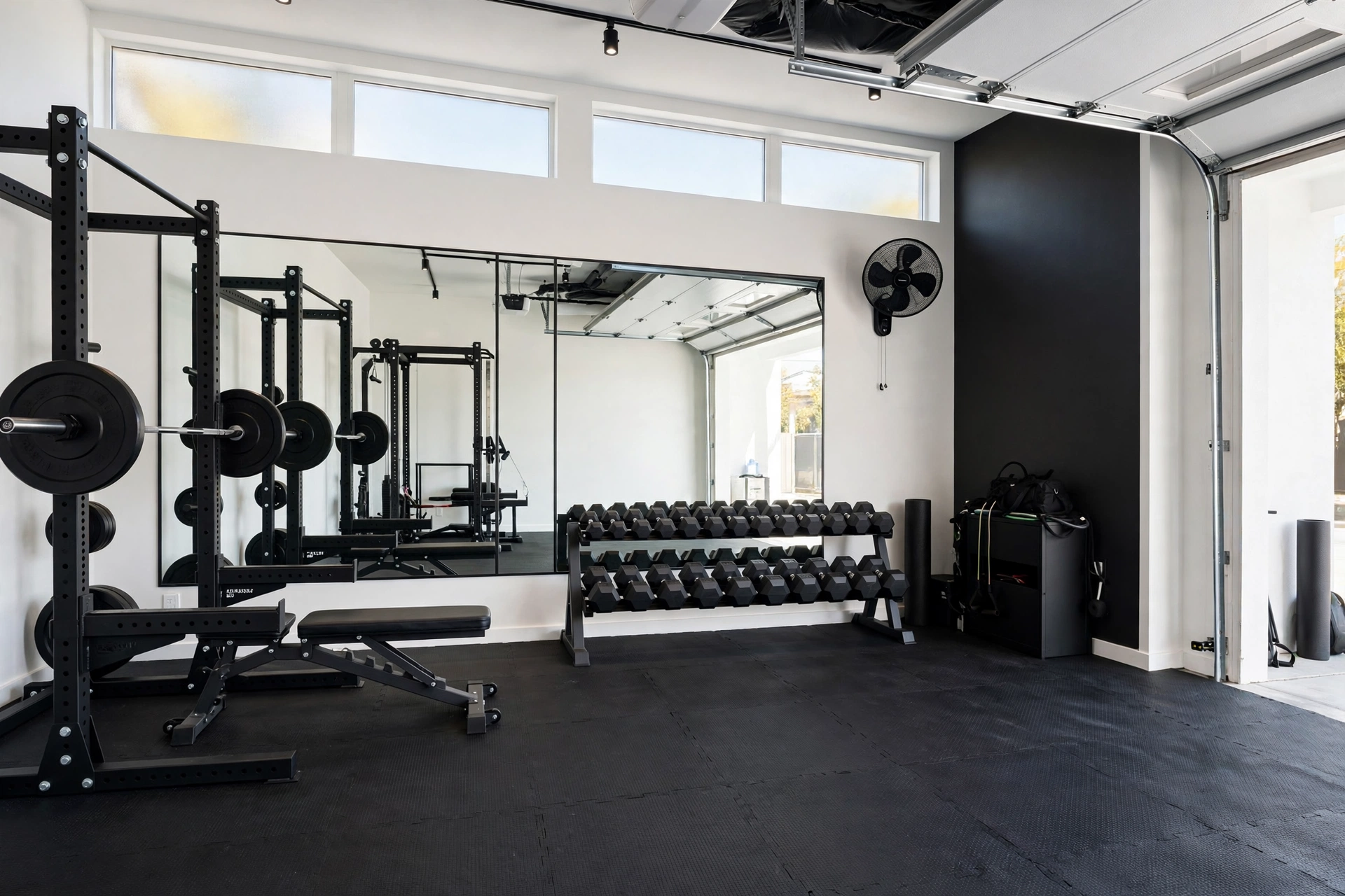 Garage home gym with squat rack, dumbbells and mirror wall