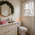 Festive Christmas powder room with mini tree, garland, and warm holiday decor