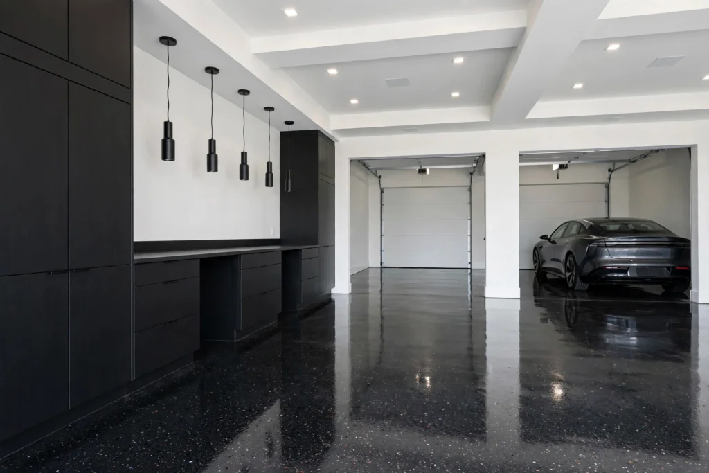 Modern garage interior with glossy epoxy flooring, built-in cabinetry and warm LED lighting