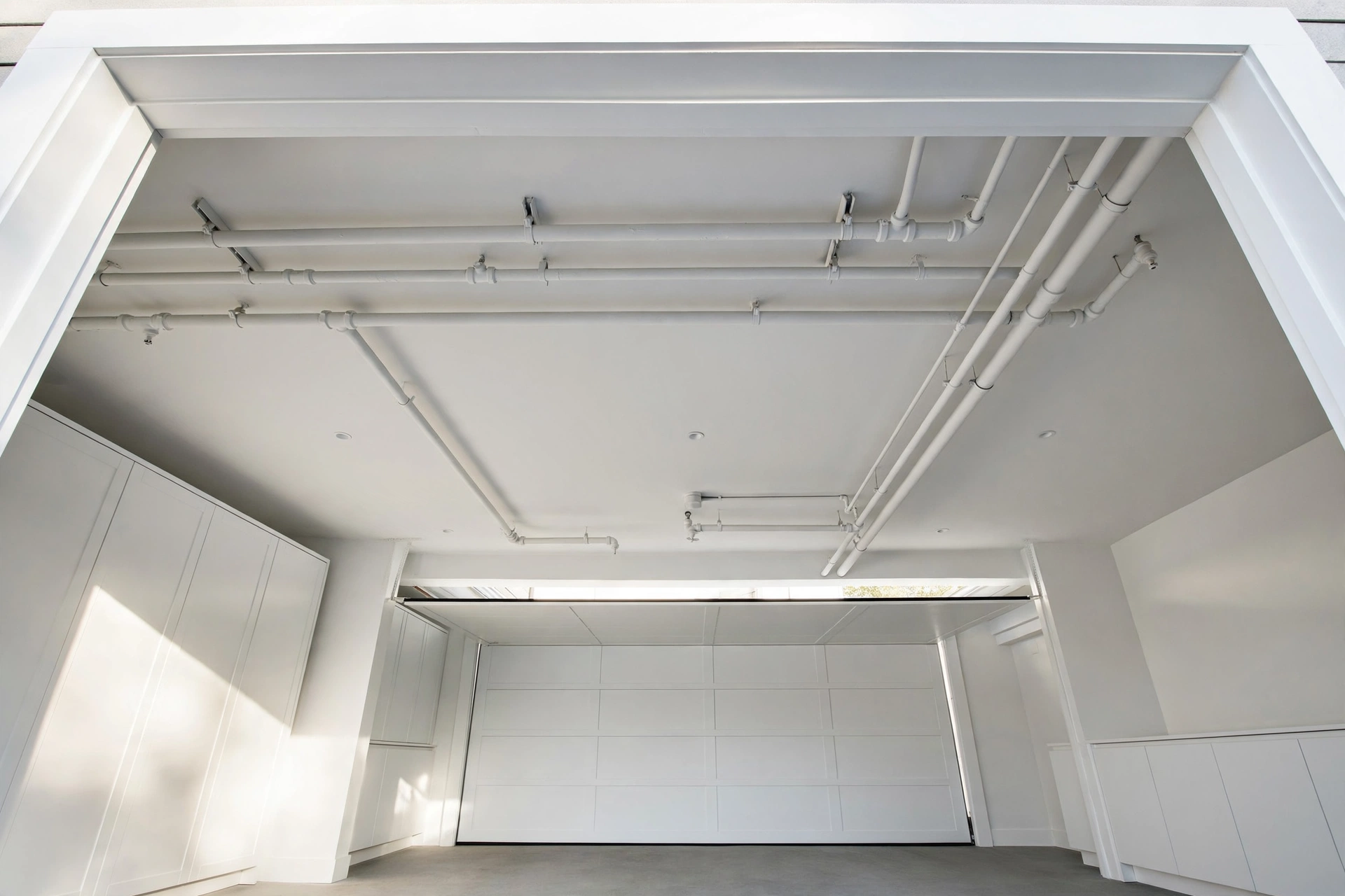 Garage with a freshly painted dark ceiling and recessed lighting