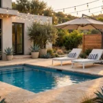 Styled backyard pool area at golden hour with sun loungers, striped pillows and cantilever umbrella